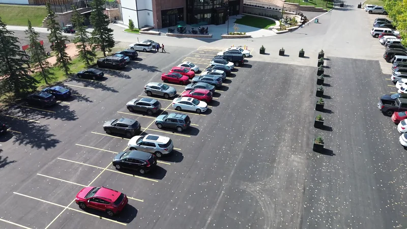 Finished, line-painted commercial parking lot in Calgary with cars parked on the new asphalt