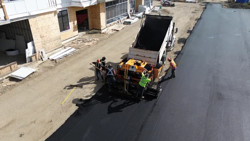 Aerial view of the Commercial Paving crew raking hot mix asphalt behind the paver