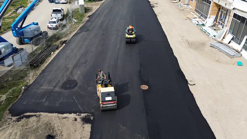 Two rollers compacting a freshly paved asphalt lane