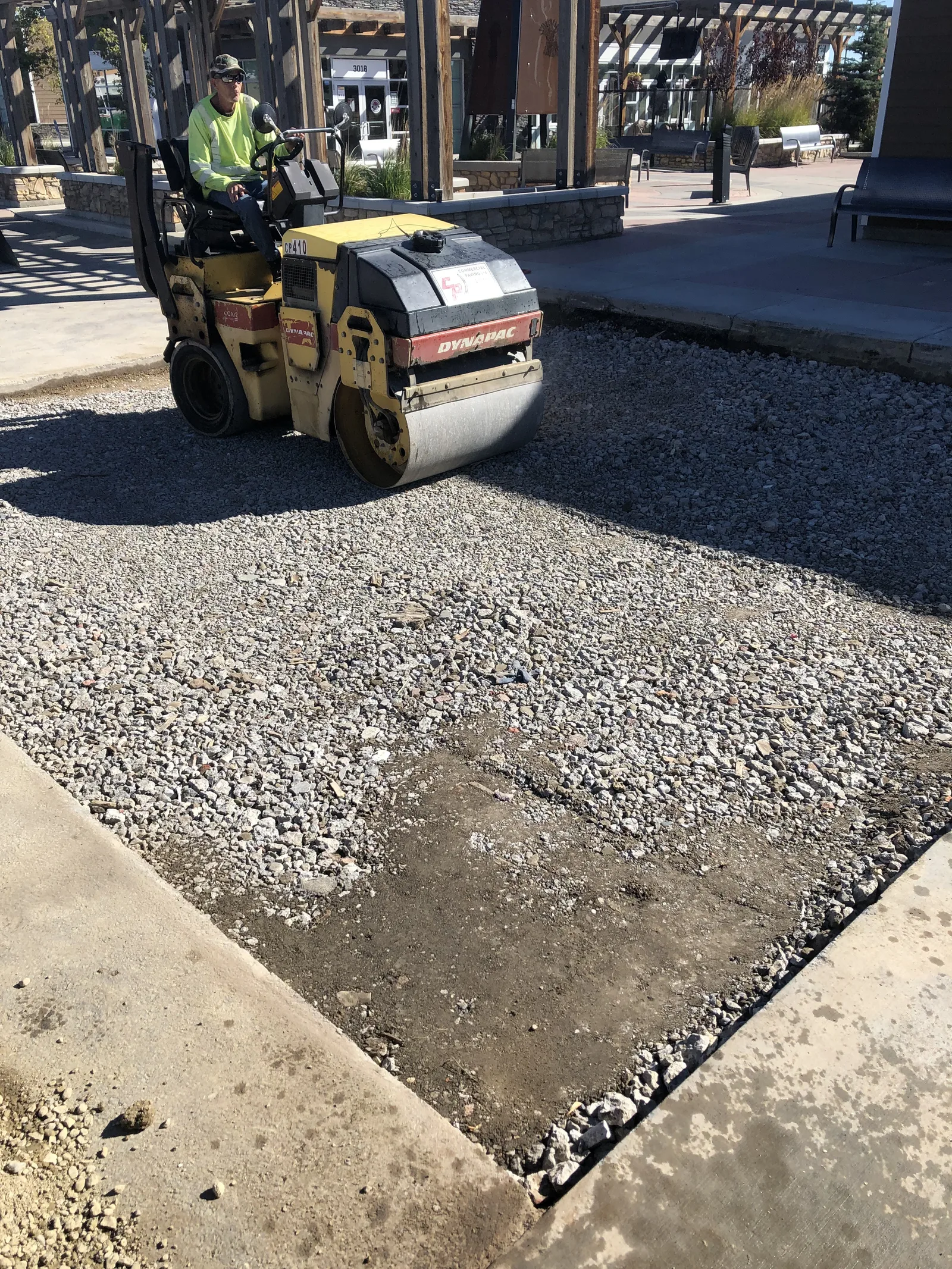 Roller compacting base for parking lot patch