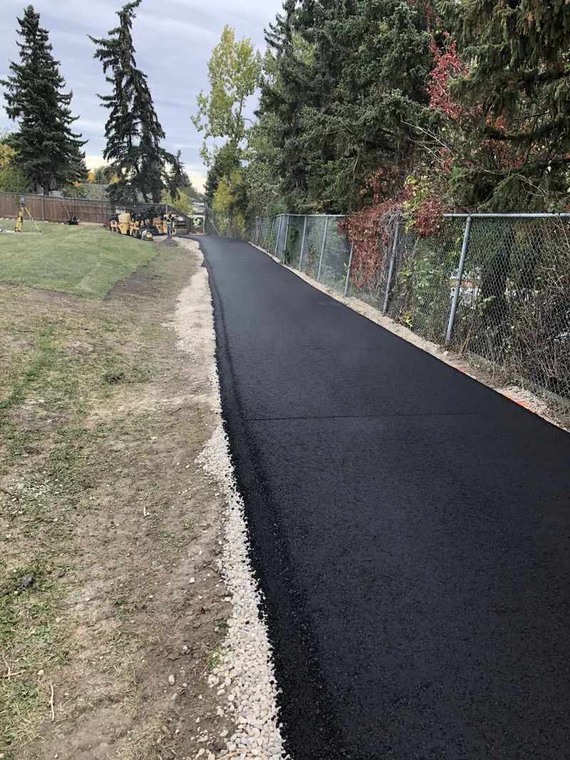 Freshly paved asphalt pathway through a Calgary green space